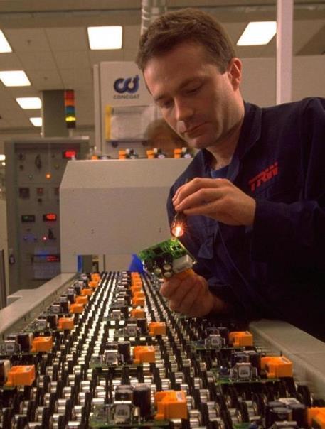 A technician inspects some of the plants output of air bag crash sensors that are marketed to European automotive customers.